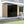 Load image into Gallery viewer, Modern house exterior with a large reflective surface and wooden paneling.