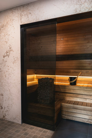 Compact home sauna with wooden interior, designed to fit in small spaces, featuring built-in benches and soft lighting for a cozy and relaxing atmosphere.