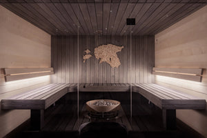 Wooden sauna interior with benches and a fire pit.