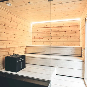 Wooden sauna with bench and heater by Finnish Sauna Builders