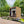 Modern garden shed with wooden exterior on a deck surrounded by greenery