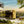 Modern house with a reflective gold exterior in a scenic landscape.